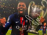Le footballeur tient un trophée dans ses mains.