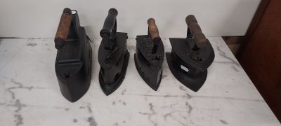 four pairs of black leather shoes are lined up on a counter