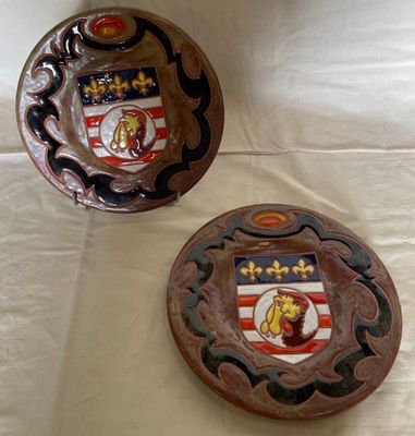 two decorative plates on a table with a white background