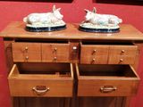two sheep figurines sitting on top of a wooden dresser