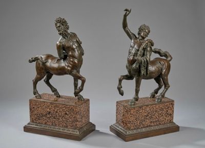 pair of bronze statues of a man on a horse and a woman on a horse