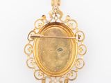 an image of a gold plated pendant with a face in the center