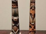 two wooden carvings sitting on a table next to each other
