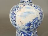 a blue and white vase with a picture of a boat on it