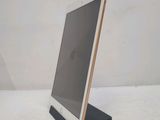 tablet computer sitting on top of a wooden stand on a white surface