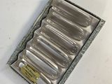 a box of six silver spoons sitting on a table