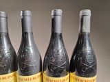 four bottles of wine are lined up on a table