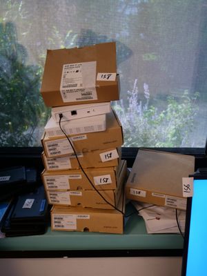 a stack of boxes sitting on a window sill next to a laptop