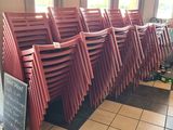 many red chairs lined up in a row in a restaurant