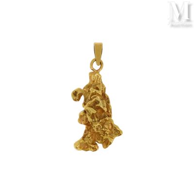 un gros plan d'un petit pendentif en forme d'ourson doré sur fond blanc