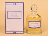 un flacon de parfum et un coffret de parfum posés sur une surface jaune