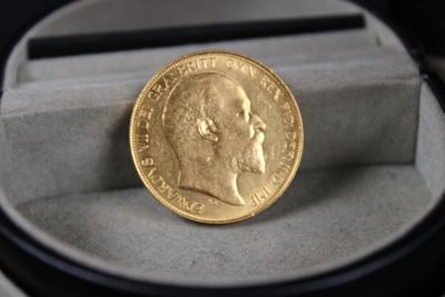 une pièce d'or posée dans une boîte sur une table