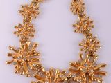 a gold necklace on a white background