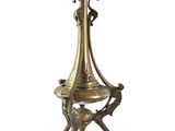 an antique brass candle holder on a stand on a white background