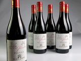 six bouteilles de vin sont alignées sur une table