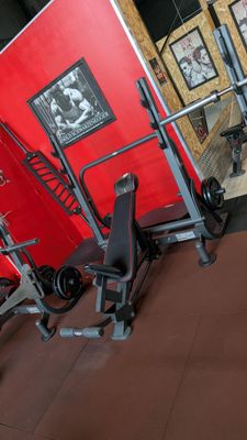 a gym room with a red wall and a black and white gym equipment