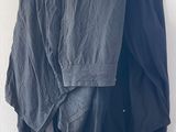 a black jacket hanging on a white wall next to a pair of black pants