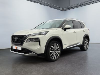 Un SUV Nissan blanc est garé dans une grande pièce.