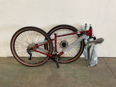 un vélo appuyé contre un mur, à côté d'une poubelle