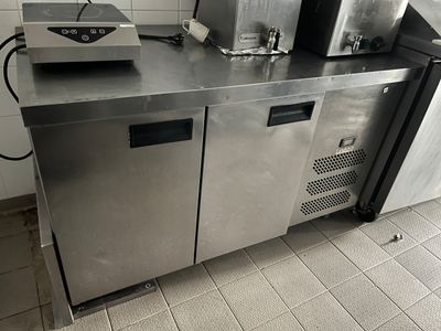 stainless steel counter top in a commercial kitchen with two coffee machines on it