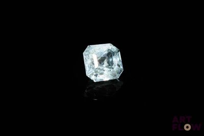 a close up of a blue diamond on a black surface