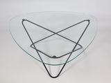 a glass coffee table with a metal base and a triangular glass top