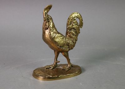 une statue en or représentant un coq debout sur un socle