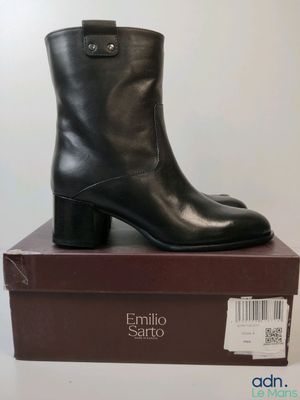 une paire de bottines noires posée sur une boîte