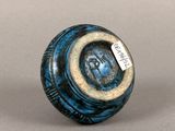 a blue and black vase with a tag on it