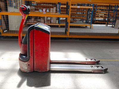 un chariot élévateur rouge garé au milieu d'un entrepôt