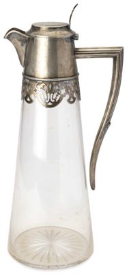 un pichet en verre muni d'une poignée en métal, sur fond blanc