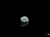 a close up of a green diamond on a black surface