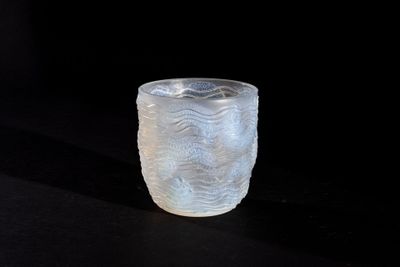 a frosted glass cup sitting on a black surface