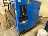 a blue machine sitting inside of a building next to a blue container
