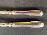 two silverware spoons on a table with a black background