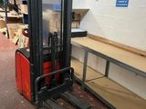 a fork lift truck in a warehouse with boxes on the floor