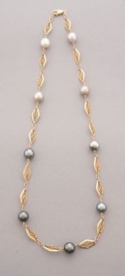 a close up of a necklace with pearls and gold chains