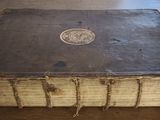 an old book sitting on the floor with a medallion on it