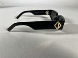 black and gold sunglasses on a white surface with a white background