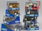 Plusieurs boîtes contenant des modèles réduits de voitures de différents types sont empilées les unes sur les autres.