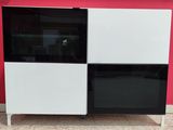a black and white cabinet with a red wall behind it