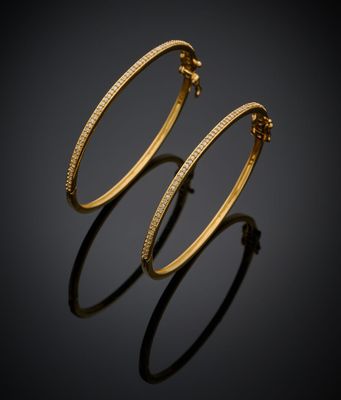 une paire de boucles d'oreilles en or sur fond noir