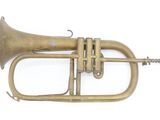 an old brass trumpet sitting on top of a white surface