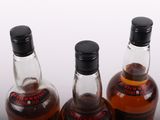 three bottles of whiskey sitting on top of a table next to each other