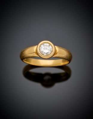 a yellow gold ring with a single diamond in the center