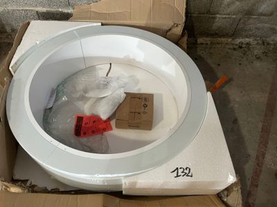 une cuvette de WC blanche avec une poignée rouge, dans une boîte