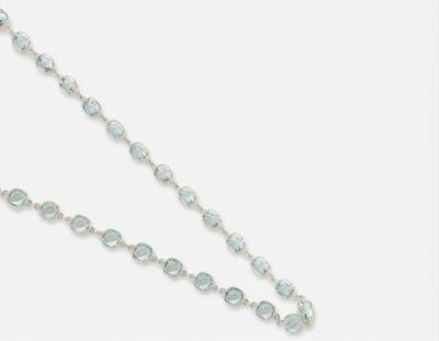un gros plan sur un long collier orné d'une croix