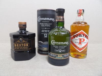 trois bouteilles de spiritueux de différentes sortes posées sur une table