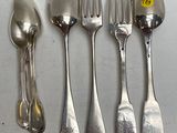 cinq cuillères en argent et deux cuillères en argent sur une table