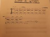 a sheet of music on a table with a pen in it